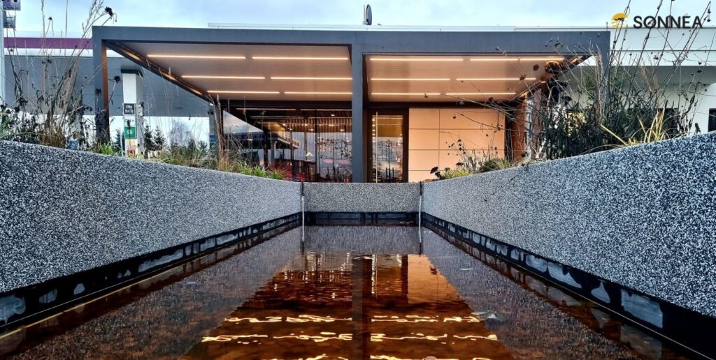 Lamelová pergola s osvětlením a žaluziemi u čerpací stanice